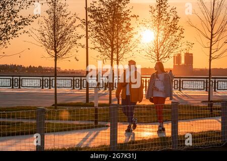 Kazan, Russie - 12 septembre 2020 : un jeune homme et une femme marchent dans une soirée d'automne ensoleillée au bord de la rivière sur le remblai de la ville Banque D'Images