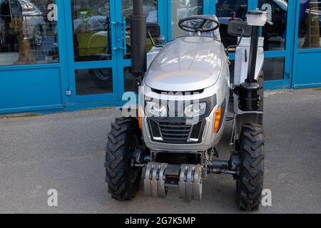 Nouveau mini-tracteur dans le parking à l'entrée du marché agricole, équipement pour le travail agricole. Banque D'Images