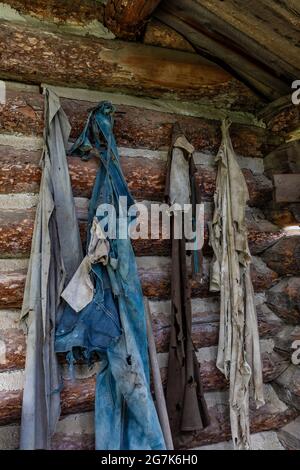 Des restes de vêtements dans une cabane en rondins dans la ville fantôme de Garnet, une ville qui abrite autrefois des mineurs d'or et leurs familles, Montana, États-Unis Banque D'Images