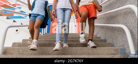 Trois camarades de classe, Caucasiens, marchant dans les escaliers de l'école Banque D'Images