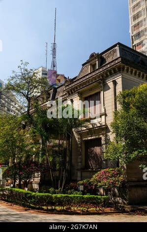 Vue partielle sur le grand manoir de style français Casa das Rosas domaine avec son beau jardin en face sous ciel bleu clair ensoleillé. Banque D'Images