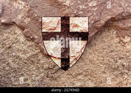 Icône de croix d'ordre teutonique isolée sur fond de mur de roche solide et abîmé Banque D'Images