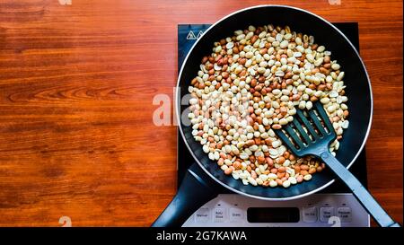 Vue de dessus des cacahuètes grillées dans une poêle sur une table en bois Banque D'Images