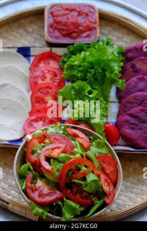 Incroyable nourriture de matière première colorée pour hamburger vegan de patate douce violette avec sauce tomate, salade, concombre, nourriture saine pour le petit déjeuner qui ri Banque D'Images