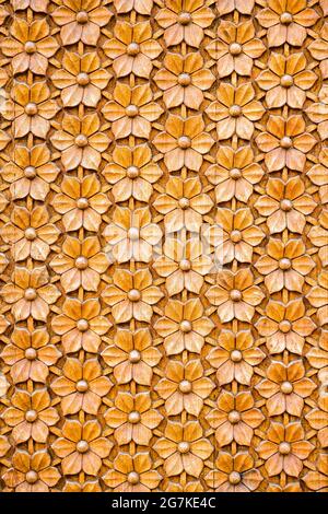 Fragment de l'ancienne porte en bois sculpté avec un motif floral en relief en bois diagonalement naturel recouvert d'un vernis incolore artisanal Banque D'Images