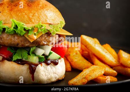 Gros plan de savoureux hamburger de porc frais avec frites Banque D'Images