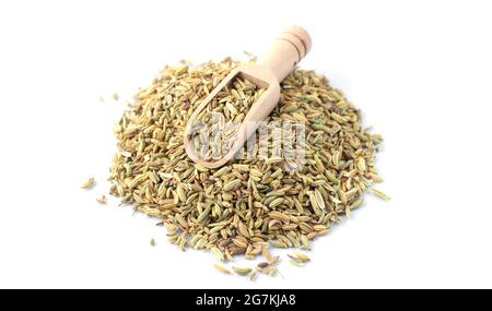 Pile de graines de fenouil séchées avec une pelle en bois isolée sur fond blanc Banque D'Images