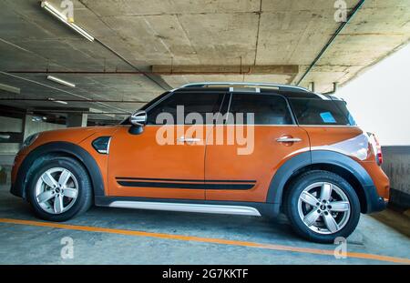 Bangkok, Thaïlande - 30 juin 2021 : vue latérale de la belle mini cooper marron brillant garée dans le parking. Mise au point sélective. Banque D'Images