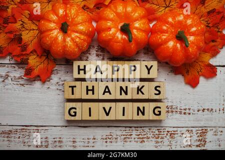 Bonne lettre de l'alphabet de Thanksgiving avec citrouilles et feuilles d'automne sur fond de bois Banque D'Images