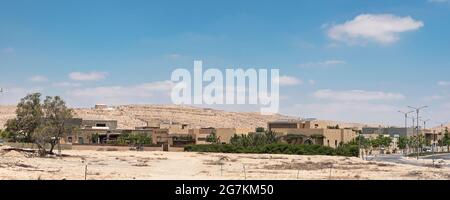 Une ville désertique moderne dans le Negev en Israël où la construction est appropriée pour la zone aride montrant des terres non développées et un réservoir d'eau Banque D'Images