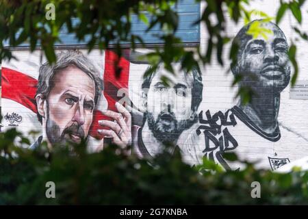 Londres, Royaume-Uni. 14 juillet 2021. Photo prise le 14 juillet 2021 montre une fresque de l'équipe de football d'Angleterre, dont le Manager Gareth Southgate (L), les footballeurs Harry Kane (C) et Raheem Sterling à Londres, en Grande-Bretagne. Une fresque présentant le directeur de l'Angleterre, Gareth Southgate, le capitaine Harry Kane et le vedette Raheem Sterling, a été dévoilée mardi à Londres pour célébrer la réussite de l'équipe à la finale de l'Euro 2020. Credit: Ray Tang/Xinhua/Alay Live News Banque D'Images