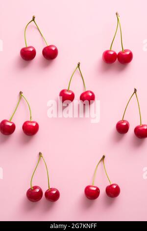 Cerises rouges mûres sur fond rose. Flat lay, vue de dessus. Banque D'Images
