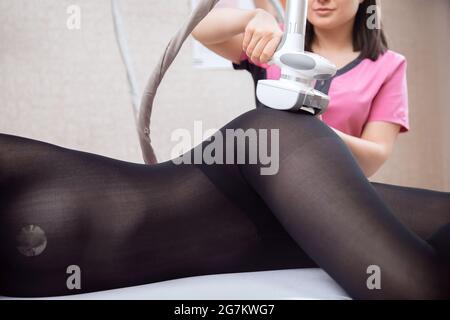 La femme reçoit un massage GPL pour enlever la cellulite de son corps, pour lever les jambes. Salon de beauté concept. Banque D'Images