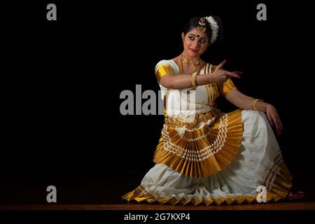 Mohiniattam danseuse assise avec sa main devant le mudra d'Ardhachandra Banque D'Images