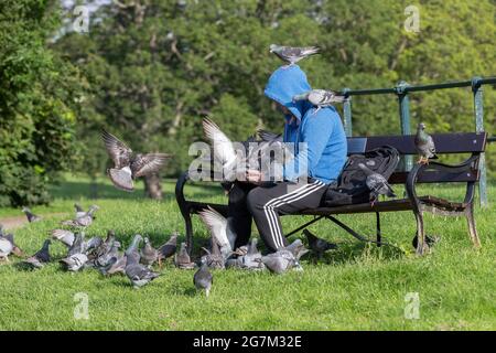 Northampton, Royaume-Uni. 15 juillet 2021. Gary Stone un lad local nourrissant les pigeons de report à Abington Park. Crédit : Keith J Smith./Alamy Live News Banque D'Images