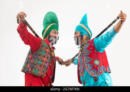 Deux danseurs de Bhangra debout avec Kcentia derrière leur cou. Banque D'Images