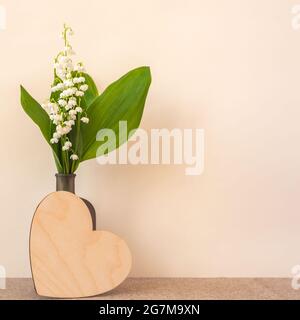 Nénuphars de la vallée en bouteille et coeur en bois beige Banque D'Images