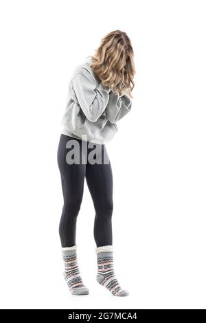 Femme méconnaissable dans des vêtements de maison avec des éternuements ou une toux de cheveux foiré. Corps entier isolé sur fond blanc. Banque D'Images