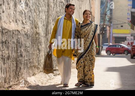 UN COUPLE RURAL SE PROMENANT VOLONTIERS ENSEMBLE LORS D'UNE JOURNÉE ENSOLEILLÉE Banque D'Images