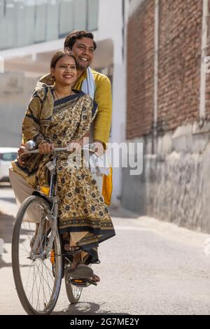 UN COUPLE RURAL HEUREUX DE MONTER UN VÉLO ENSEMBLE Banque D'Images