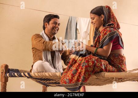UN COUPLE RURAL ASSIS ENSEMBLE ET BUVANT DU THÉ Banque D'Images