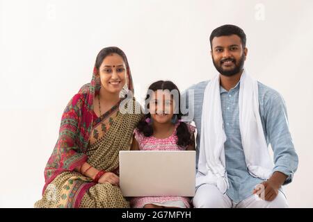 PORTRAIT D'UNE FAMILLE RURALE AVEC UN ORDINATEUR PORTABLE Banque D'Images