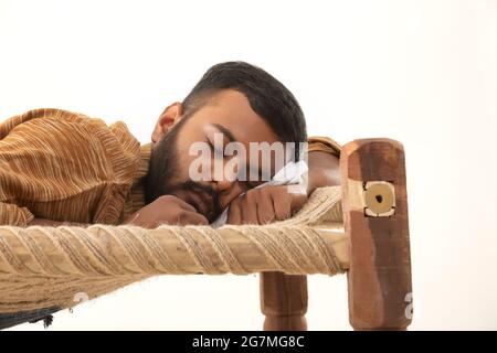 GROS PLAN D'UN HOMME RURAL DORMANT SUR UN LIT DE CAMP Banque D'Images