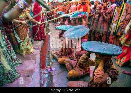 Les hommes de Barsana raid la ville voisine de Nandgaon et sont battus par les femmes de Nandgaon avec de grands bâtons et étalé avec des poudres de couleur Holi Banque D'Images