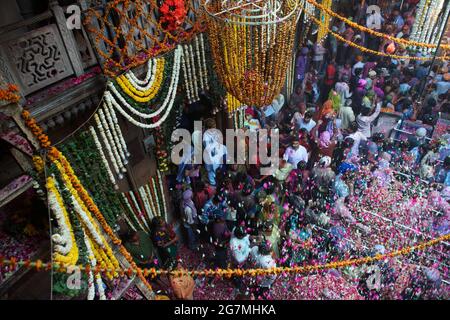 Les pétales de fleurs pleuvent sur les dévotés et les fêtards réunis au temple de Bankey Bihari à Vrindavan lors de l'ouverture d'un festival de culte de 5 jours Banque D'Images