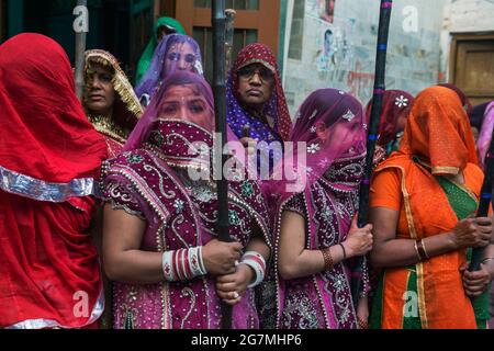 Des hommes de Barsana raid dans la ville voisine de Nandgaon et sont battus par les femmes de Nandgaon avec de grands bâtons et tachés avec des poudres de couleur Holi Banque D'Images