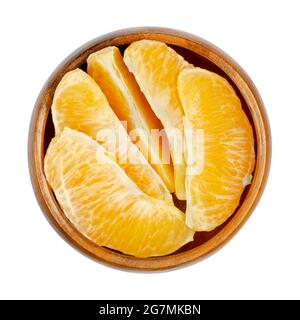 Segments orange, dans un bol en bois. Segments d'une orange de Valence pelée. Un fruit mûr et doux à la chair de fruits jaune et juteuse. Banque D'Images
