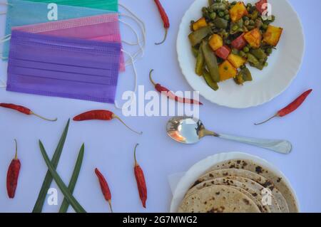 Nourriture indienne : mélanger la recette de paneer de matar et de mirch de shimla avec le chapati (roti) et le masque facial sur la table blanche Banque D'Images