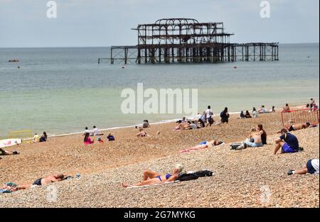 Brighton Royaume-Uni 15 juillet 2021 - les visiteurs sur la plage de Brighton profitent d'un mélange de soleil et de nuages lors d'une journée chaude et brumeux le long de la côte sud. Une vague de chaleur est prévue pour plus tard dans la semaine et le week-end à travers la Grande-Bretagne avec des températures qui devraient atteindre le centigrade élevé de 20s dans certaines parties : crédit Simon Dack / Alamy Live News Banque D'Images