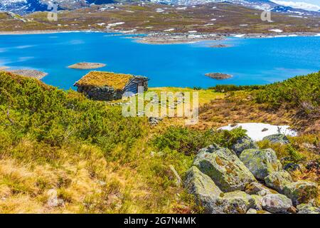 Magnifique panorama sur le lac Vavatn vue sur le paysage brut des cottages et des montagnes avec de la neige pendant l'été à Hemsedal Norvège. Banque D'Images