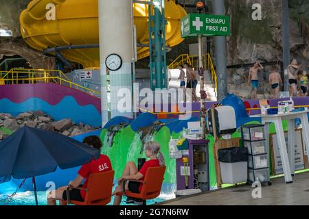 Helsinki, Estonie-07.04.2021: Station de surveillance de la vie près de la piscine. Services Serena Park S.O.S. Station de premiers soins près de l'eau. Homme avec rouge Save Our Souls T shirt près de la station medic Banque D'Images