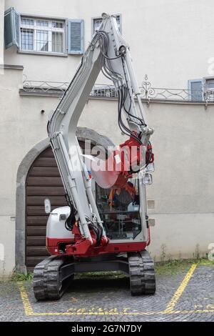 un creuseur blanc sur une place de stationnement dans la ville Banque D'Images