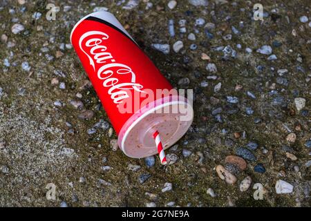 Coupe de papier avec Coca Cola laissée dans un lieu public dans une rue à Bucarest, Roumanie, 2021 Banque D'Images