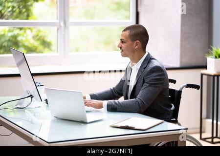 Homme d'affaires handicapé utilisant un ordinateur portable au bureau Banque D'Images