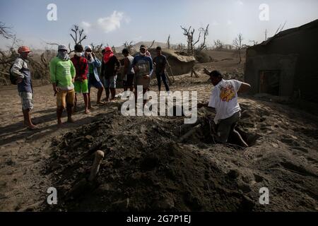 Les résidents épargnent leurs effets personnels de leurs maisons couvertes de cendres alors que le volcan Taal convie à montrer des signes d'une explosion dangereuse imminente dans la province de Batangas au sud de Manille. Taal, le deuxième volcan le plus actif du pays, a émis un panache sombre de vapeur et de cendres lors d'une brève explosion, indiquant qu'une éruption explosive dangereuse est possible en heures ou en jours. L'explosion a posé la menace d'une autre éruption qui a conduit à l'évacuation de milliers de villageois à l'intérieur de la zone de danger du volcan ou des zones à haut risque. Philippines. Banque D'Images