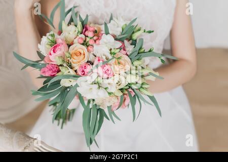 Mariée avec un bouquet de mariage dans ses mains avec des fleurs roses Banque D'Images