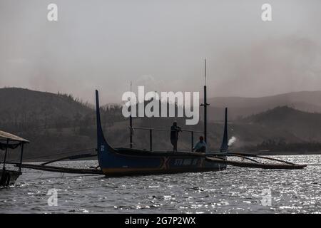 Les résidents qui vivent sur l'île du volcan Taal fuient en utilisant des bateaux tandis que le volcan Taal continue d'extacher de la fumée et des cendres à Laurel, province de Batangas au sud de Manille. Taal, le deuxième volcan le plus actif du pays, a émis un panache sombre de vapeur et de cendres lors d'une brève explosion, indiquant qu'une éruption explosive dangereuse est possible en heures ou en jours. L'explosion a posé la menace d'une autre éruption qui a conduit à l'évacuation de milliers de villageois à l'intérieur de la zone de danger du volcan ou des zones à haut risque. Philippines. Banque D'Images