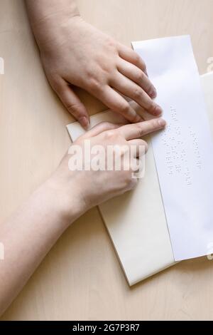 vue de dessus de la femme aveugle lit une note en braille sur la feuille de papier gros plan Banque D'Images