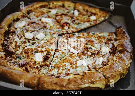 pizza « four cheese » dans une boîte en carton. tranchez de délicieuses pizzas dans une boîte de livraison. pizza savoureuse fraîchement cuite vue isométrique Banque D'Images
