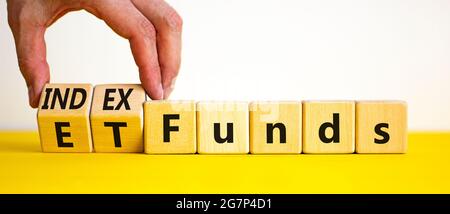 Fonds indiciels vs symbole ETF. Homme d'affaires transforme un cube et change les mots « ETF, Exchange-Traded Fund » en « Index Funds. Magnifique fond blanc, copie sp Banque D'Images