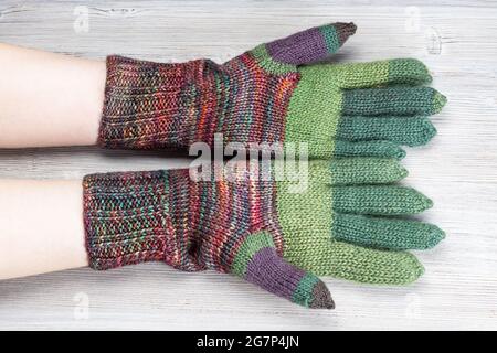 paume des mains des femmes en gants tricotés sur une table grise Banque D'Images