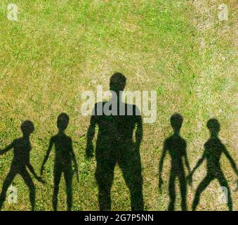 Illustration du concept SCI-fi. Hommes et extraterrestres silhouettes noires jetant l'ombre sur l'herbe verte avec l'espace de copie Banque D'Images