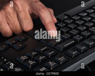 Personne appuyant sur la touche entrée d'un clavier noir. Gros plan. Touche Bas Banque D'Images