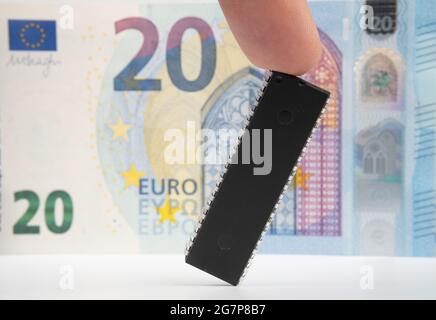 Grande puce d'ordinateur placée à côté de 20 euros de billet de banque. Concept d'investissement dans l'industrie des semi-conducteurs et la pénurie de puces d'or. Banque D'Images
