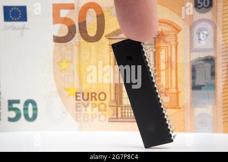 Grande puce d'ordinateur placée à côté de 50 euros de billet de banque. Concept d'investissement dans l'industrie des semi-conducteurs et la pénurie de puces d'or. Banque D'Images