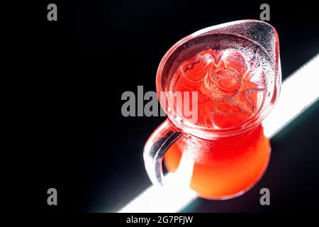 limonade aux baies rouges ou boisson aux fraises avec glace dans un pot en verre sur fond noir Banque D'Images